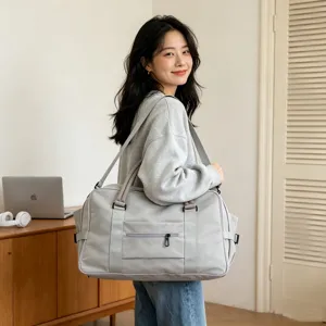 Vista dettagliata della borsa da viaggio in nylon grigio chiaro con tracolla e tasca.