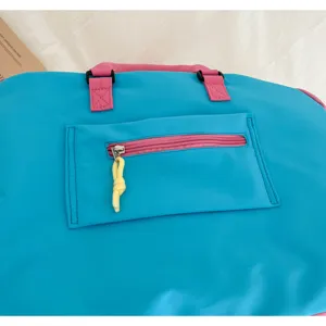 Bunte Reise-Sporttasche mit kontrastierenden rosa Griffen und Vordertasche für Fitness und Yoga.