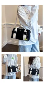 Schwarz-weiße Canvas-Umhängetasche mit Tennisschläger-Anhänger für den Alltag.