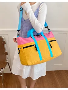 Color-block travel duffel bag for women, large capacity waterproof sports gym shoulder bag.