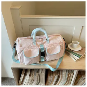 Borsa da viaggio rosa con manici azzurri, tasche multiple e tracolla per la palestra.