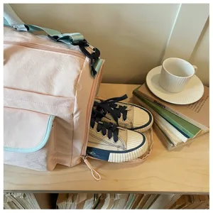 Vista dettagliata della borsa da viaggio sportiva rosa con scomparto scarpe e tasche.
