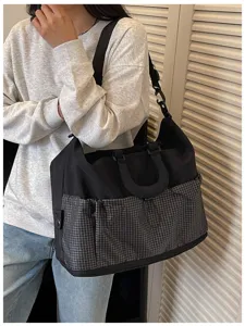 Detailansicht der großen Reise-Umhängetasche mit einzigartigem Karomuster-Taschendesign.