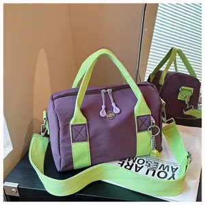 Detailansicht der violett-grünen Reisetasche mit stabilen Griffen und Reißverschluss.