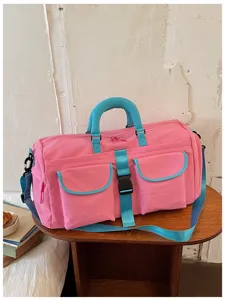 Vista dettagliata della borsa sportiva rosa con tasche anteriori, manici blu e cinghia.