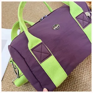 Nahaufnahme des lila-grünen Kinder-Reisetasche-Details, die Stoff- und Gurttextur zeigt.