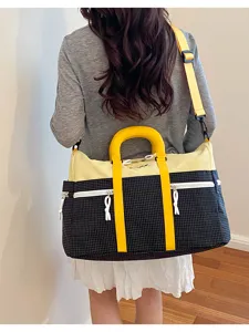 Detailed view of the color block duffel bag showcasing its spacious design and stylish straps.