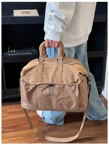 Detailansicht der großen Reisetasche mit Karomuster, robustem Griff und Schultergurt.