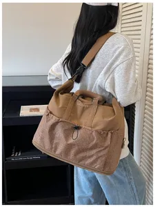 Grosse Reisetasche mit Karo-Muster und stylischem Schultergurt fuer Kurztrips und Sport.