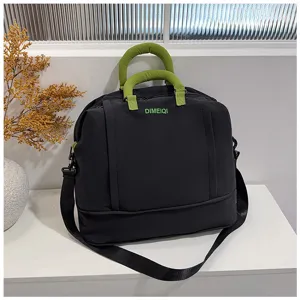 Vista dettagliata della grande borsa da viaggio nera con manici verdi e logo personalizzato.