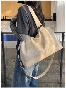 Large capacity canvas travel duffel bag for women, stylish portable shoulder luggage bag.