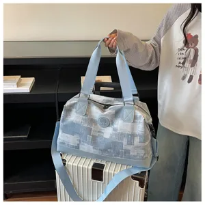 Detailed view of the stylish blue patterned canvas travel duffel bag with sturdy straps.