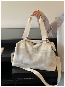 Beige travel duffel bag for women, large capacity canvas weekender bag with sturdy handles.