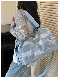 Detail view of large capacity blue white printed travel duffel bag with shoulder strap.