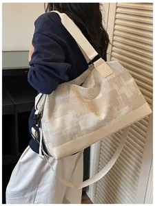 Detail view of large capacity travel duffel bag with shoulder strap and stylish canvas design.