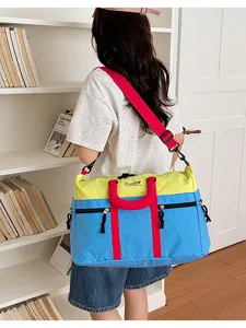 Color block travel duffel bag detail, featuring durable shoulder strap and spacious design.