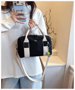 Schwarze Canvas Boston-Tasche mit weißen Trägern, süßer Tennisschläger-Anhänger, lässige Tasche.