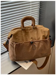 Detailansicht der großen braunen Reisetasche mit Vordertasche und stabilem Griff.