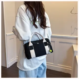 Nahaufnahme einer schwarz-weißen Segeltuch Reisetasche mit Tennisschläger Anhänger.