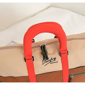 Close-up detail of travel duffel bag handle, color-block design, durable canvas and grid.