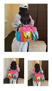 Detail view of the colorful multi-pocket yoga travel bag worn by a model indoors.