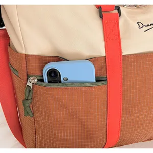 Color-blocked travel tote bag with large capacity, durable canvas and front pocket.