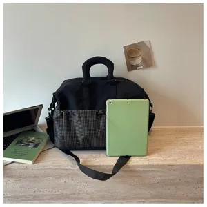 Detailansicht der schwarzen Reisetasche mit Karo-Muster, geräumigem Fach und stabilen Riemen.