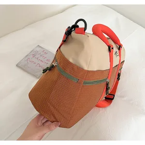 Color-blocked travel luggage bag featuring large capacity, durable fabric and vibrant orange straps.