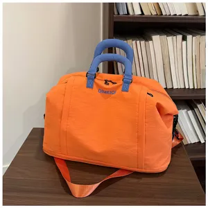 Grande borsa da viaggio arancione con manici blu e tracolla in vista dettagliata