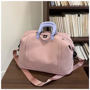 Grande borsa da viaggio rosa con manici blu e tracolla per palestra e sport quotidiani.