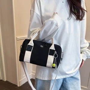 Schwarze Canvas Boston Schultertasche mit weißen Trägern und Tennis Anhänger für den Alltag.