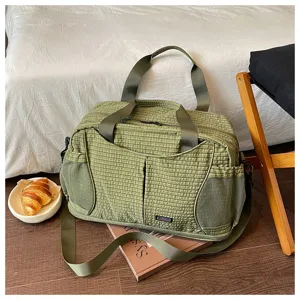 Détail de sac de voyage à carreaux verts, sac de sport léger avec poches latérales en filet.