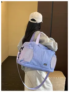 Vue détaillée du sac de voyage matelassé violet clair avec poches latérales en filet.