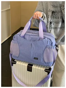 Vue détaillée du sac de voyage matelassé avec des poches latérales en filet et des sangles.