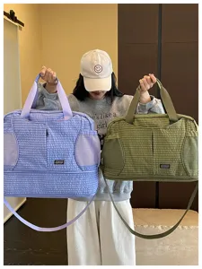 Vue détaillée du grand sac de voyage et de sport à motifs quadrillés et poches multiples.