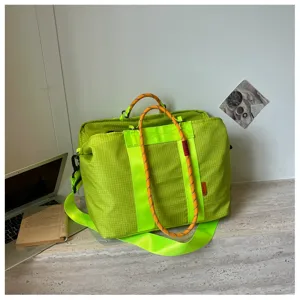 Gros plan sur le sac de voyage fitness à carreaux vert néon élégant avec poignées en corde orange.
