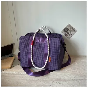 Vue détaillée du sac de sport à carreaux violets avec poignées en corde et sangle.