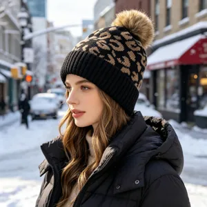 Gorro de invierno para mujer con estampado de leopardo, pompón y vuelta negra elegante.