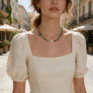 Detail view of a vintage green gemstone chip and pearl clavicle chain necklace for women.