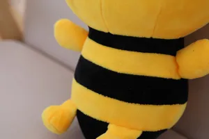 Dettaglio primo piano di dolce peluche ape a righe gialle e nere stile cartone.