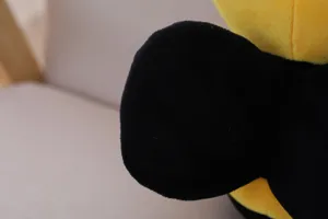 Primo piano sui dettagli del peluche ape, consistenza morbida e colori vivaci.