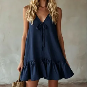 Detail shot of summer navy blue V-neck sleeveless tie-front ruffle hem mini dress texture.
