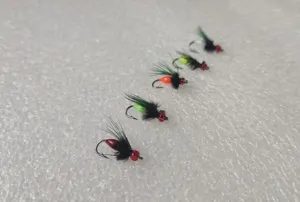 Detailed closeup of 5 colorful fly fishing hooks with feathered wings and beads for bait.