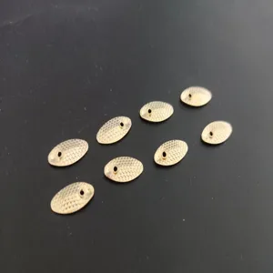Detailed view of gold fish scale fishing spoon blades, textured metal spinner parts for DIY.