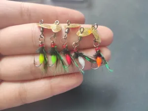 Detailed close-up of micro fishing lures featuring golden spinners and colorful feather details.
