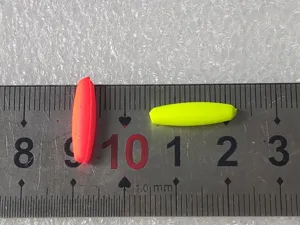 Detail view of long foam fishing float beans, bright orange and yellow tackle parts.