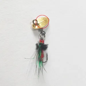 Close-up detail of gold spinner blade and feathered fly fishing hook accessory for DIY lure.