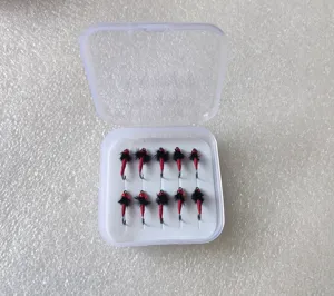Close up view of boxed fly fishing hooks, featuring red bodies and black hackles for lure fishing.