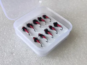 Detailed view of boxed fly fishing hooks set, featuring red and black handmade lures for trout.