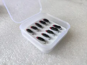 Close-up detail of fly fishing lures in a clear storage box, neatly arranged hooks.